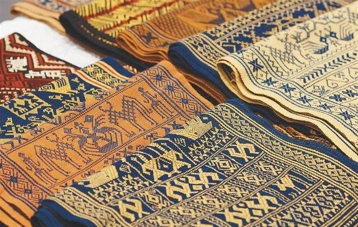 Li textiles: repeated light motifs against a dark woven ground